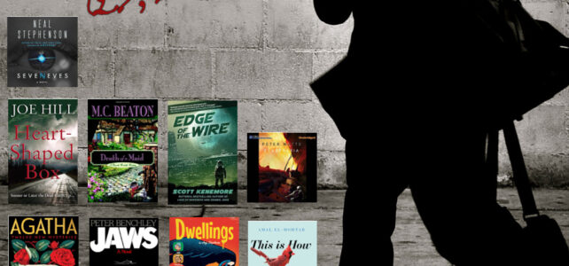 Man with messenger bag walking in the street; book covers displayed